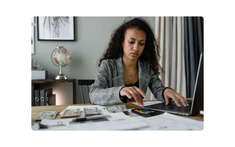 Entrepreneur analyzing finances and market trends for dropshipping product research using a laptop and calculator.